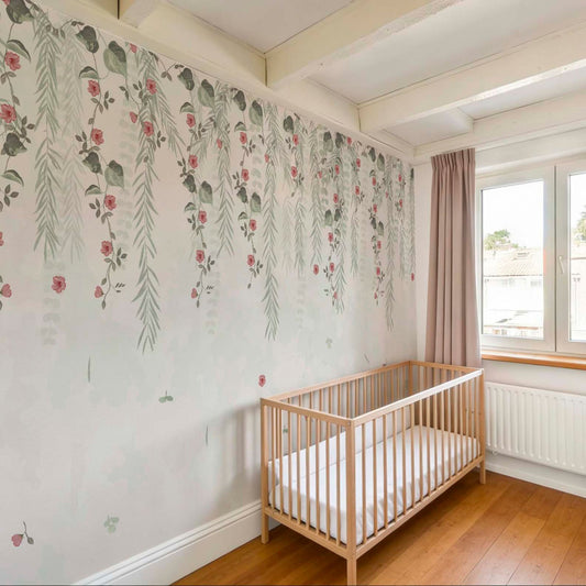 cat-610568044872 Bright nursery featuring a wallpaper mural with hanging willow branches and pink flowers, a natural wood crib, and dusty pink curtains by a sunny window.